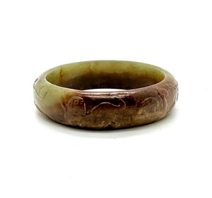 WF48 A celadon green and russet jade bangle